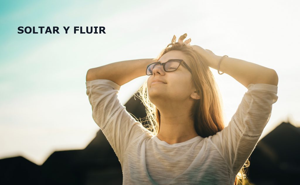 mujer brazos arriba, respira tranquila, esta presente, suelta y fluye con la vida